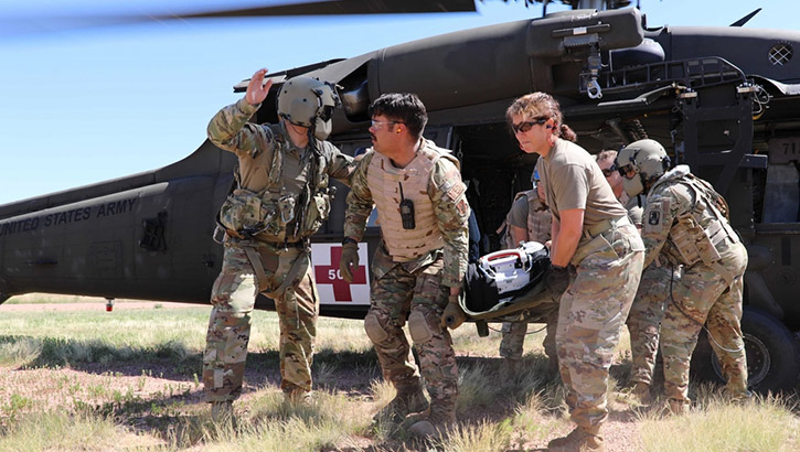 U.S. Army Reserve critical care flight paramedics from 5-159th General Support Aviation Battalion, 244th Expeditionary Combat Aviation Brigade, Army Reserve Aviation Command, guide U.S, Air Force Reserve medical personnel from the 302nd Airlift Wing in offloading a casualty from a HH-60 MEDEVAC Black Hawk during exercise Mountain Medic at Fort Carson, Colorado, on Aug. 14, 2023. Mountain Medic is an Army Reserve-led joint, multi-component, multi-domain aeromedical evacuation exercise geared at improving and reenforcing medical evacuation operations in a simulated large-scale combat operations environment. (U.S. Army Reserve Photo by Master Sgt. Joy Dulen)
