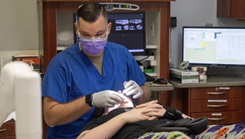 Military dental tech performs a teeth cleaning at 19 MDG