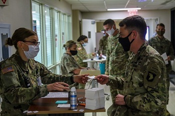 Military personnel wearing face mask checking in to receive the COVID-19 Vaccine
