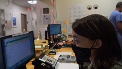 Image of military personnel, wearing a mask and looking at a computer screen