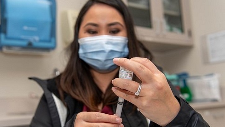 Image of Military healthcare worker holding a vaccine needle.
