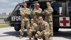 Military personnel posing next to their MedEvac helicopter