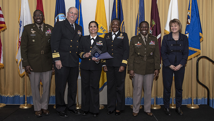 U.S. Navy Cmdr. Monica Ormeno, psychiatry specialty leader for the Naval Medical Forces Pacific in San Diego, California, received the senior Female Physician Leadership Excellence Award during the Military Health System Awards Ceremony at National Harbor, Maryland, on Feb. 16. Pictured are, from left, U.S. Army Surgeon General Lt. Gen. Scott Dingle, U.S. Navy Surgeon General Rear Adm. Bruce Gillingham, Cmdr. Ormeno, Rear Adm. Aisha Mix, chief nurse officer of the Commissioned Corps of the U.S. Public Health Service, Defense Health Agency Director U.S. Army Lt. Gen. Telita Crosland, and Seileen Mullen, principal deputy assistant secretary of defense for health affairs. Photo Credit Robert Hammer