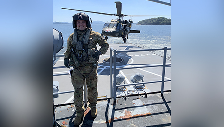 U.S. Army Capt. Zachary Herbert-Burns poses near a HH-60M Black Hawk after completing a flight session. (Photo Courtesy of Capt. Zachary Herbert-Burns). 