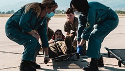 Medic prepare to lift a patient on a litter.