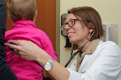 A Navy doctor examines a young patient