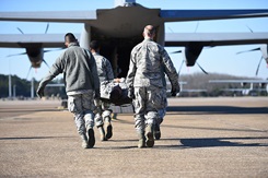 Airmen from the 19th Medical Group litter-carry a simulated patient onto a C-130J