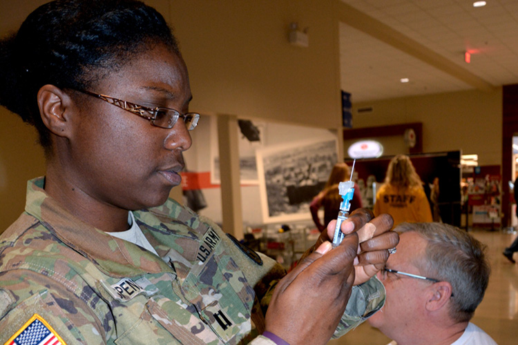 Carl R. Darnall Army Medical Center, Fort Hood, Texas, Capt Claireisa Spencer prepares to administer a flu vaccine to a Fort Hood Army Exchange customer during CRDAMC’s celebration of National Influenza Vaccination Week.