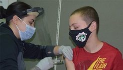 Son of military personnel receiving his COVID-19 vaccine