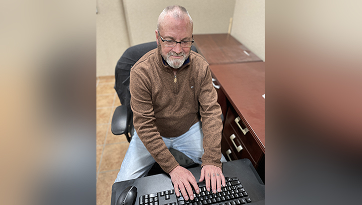 John Campbell sits at his desk as the Community Relations officer at Fort Knox Public Affairs in mid-February 2024 shortly before taking terminal leave to retire in March. (Photo: Eric Pilgrim, Fort Knox News)