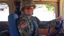 Military personnel posing for a picture while driving a truck