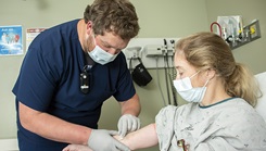 Kenneth Kallies, a registered nurse, starts an IV on an emergency room patient