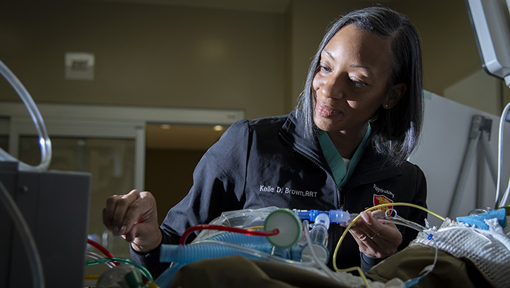 U.S. Army Staff Sgt. Kelle Brown, respiratory therapist, adjusts settings on a Volumetric Diffusive Respirator for a training simulation at Brooke Army Medical Center, Joint Base San Antonio – Fort Sam Houston, Texas, Nov. 20, 2023. Brown continues to serve on active duty after surviving stomach and breast cancer. (DoD photo by Jason W. Edwards)