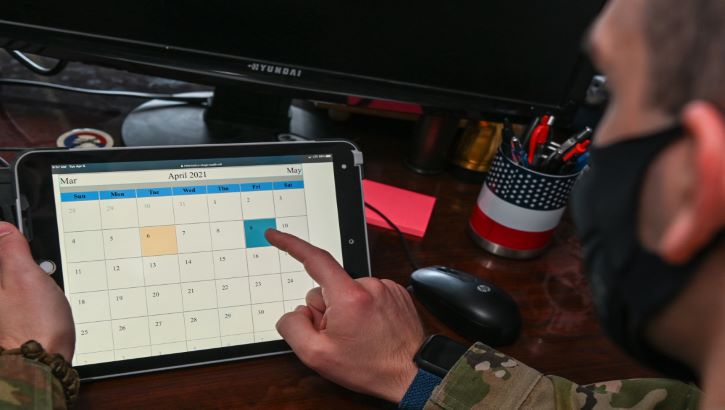 Image of Military health personnel wearing a face mask scheduling COVID-19 vaccine shots.