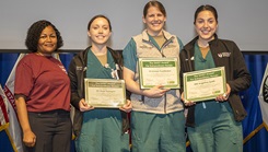 U.S. Navy Capt. Jessica Beard, chief nursing officer presents (L-R) U.S. Army 2nd Lt. Rose Flanagan, U.S. Navy Ensign Angela Spath, and U.S. Army 1st Lt. Amber Huddleston the DAISY Award during Walter Reed National Military Medical Center Director's Town Hall. (Photo: Harvey Duze)