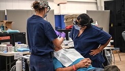 U.S. Air Force Capt. Bethanie Swanson, a dentist, and U.S. Air Force Tech. Sgt. Omalee Vega, the noncommissioned officer in charge, both assigned to the 55th Medical Group in Offutt Air Force Base, Nebraska, conduct a dental examination during Operation Healthy Delta Innovative Readiness training program in Anna, Illinois, on June 11, 2023.  (Photo: U.S. Air National Guard Airman 1st Class Danielle Dawson) 