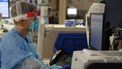 Military health personnel inputting information into a computer