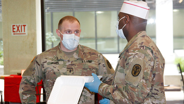 Military health personnel wearing face mask discussing food options