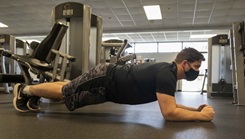 Military personnel wearing a mask exercising in the gym