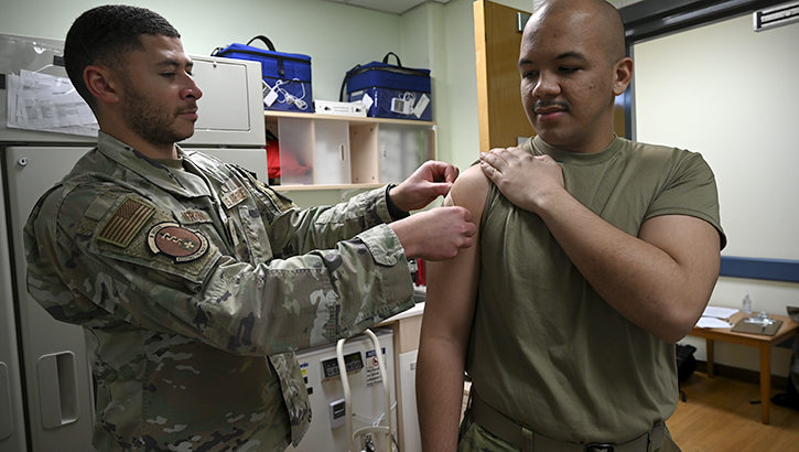 Military medical personnel immunizing a Soldier