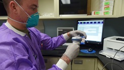 Military health personnel wearing a face mask prepares COVID-19 test samples