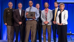 Dr. Sumil Shah accepts the Outstanding Program Management (Team) Award, along with some members of his team from Ms. Seileen Mullen, the acting secretary of Defense for Health Affairs. MHSRS provides a collaborative setting for the exchange of information between military providers with deployment experience, research and academic scientists, international partners, and industry on research and related health care initiatives, such as Combat Casualty Care, Operational Medicine, Clinical and Rehabilitative Medicine, Medical Simulation and Information Sciences, and infectious Diseases. 