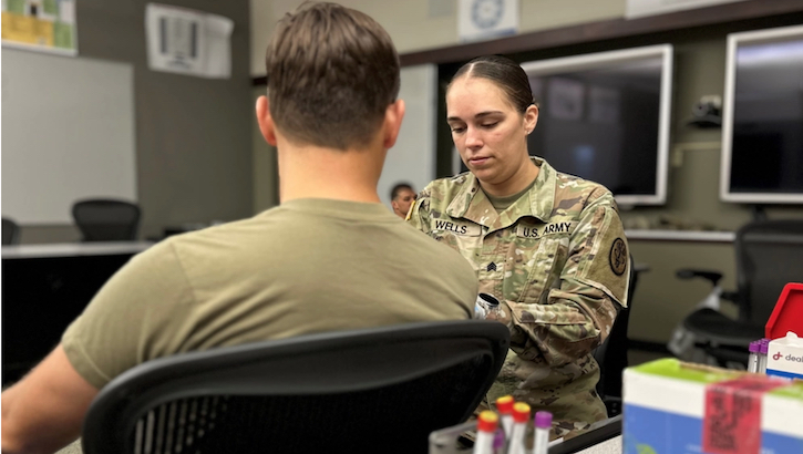 Sgt. Felicia Wells, a medical laboratory specialist assigned to Munson Army Health Center, Fort Leavenworth Kansas, collects a blood sample from a Soldier 