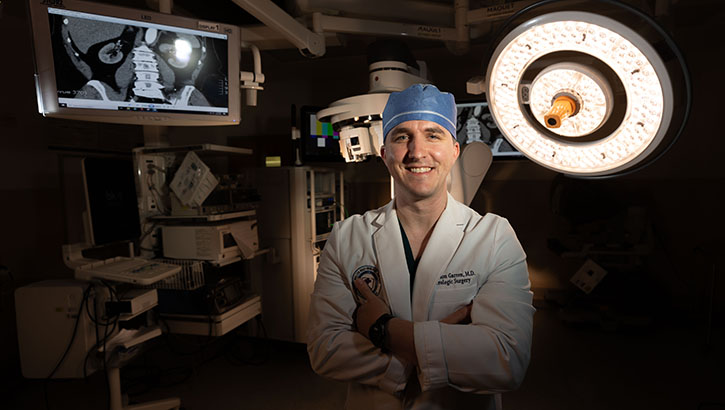 Image of U.S. Navy Lt. Cmdr. (Dr.) Brandon R. Garren, the service chief of the Department of Urology at Walter Reed National Military Medical Center, poses for a photo in the operating room. The center recently implemented a single-port robotic surgical system. (Photo: Ricardo Reyes-Guevara, Department of Defense). .