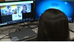 A woman faces her computer screen