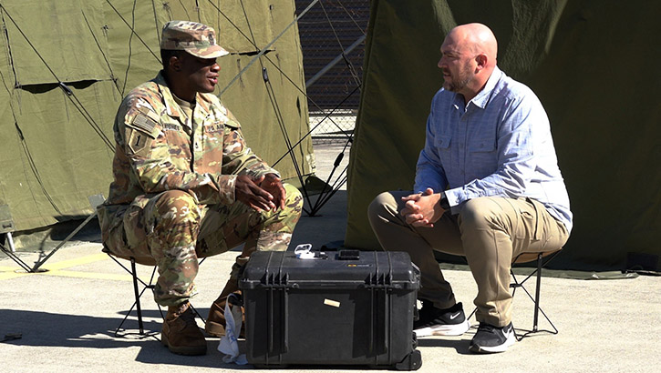 Dr. Nathan Fisher, a senior scientist, sits with U.S. Army 1st Class Timothy Hughes, public affairs chief for U.S. Army Pacific’s 18th Medical Command, which is part of the Australian Defence Force and U.S. Combined Joint Theater Medical Component, to discuss wearable pilot program technology being tested in the field during Exercise Talisman Sabre 2023 in Brisbane, Australia, on July 19, 2023. (Photo: U.S. Army Sgt. 1st Class Timothy Hughes)